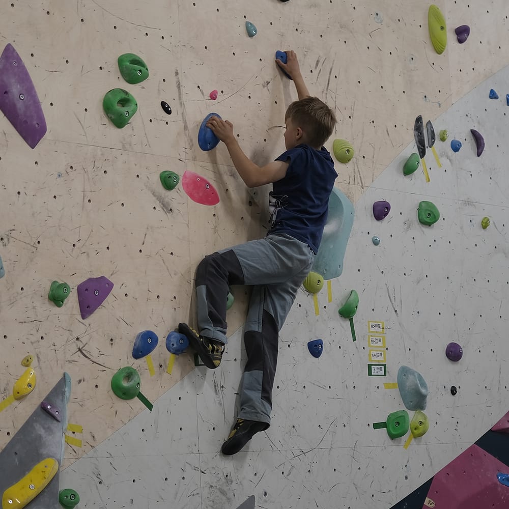 Kiipeilijä liikkeessä boulderseinällä
